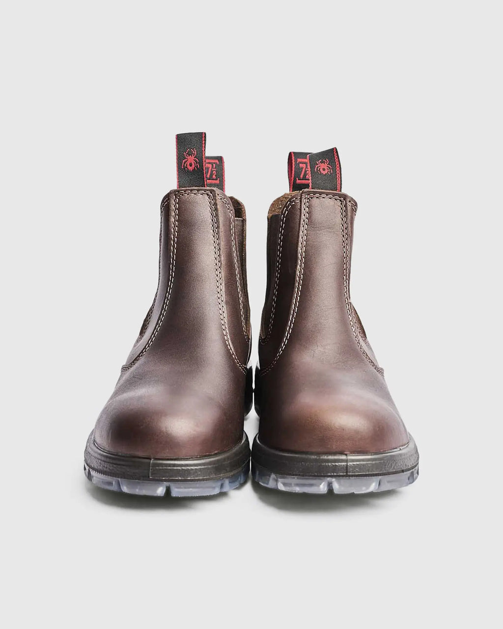 Pair of brown leather chelsea boots on a light gray background