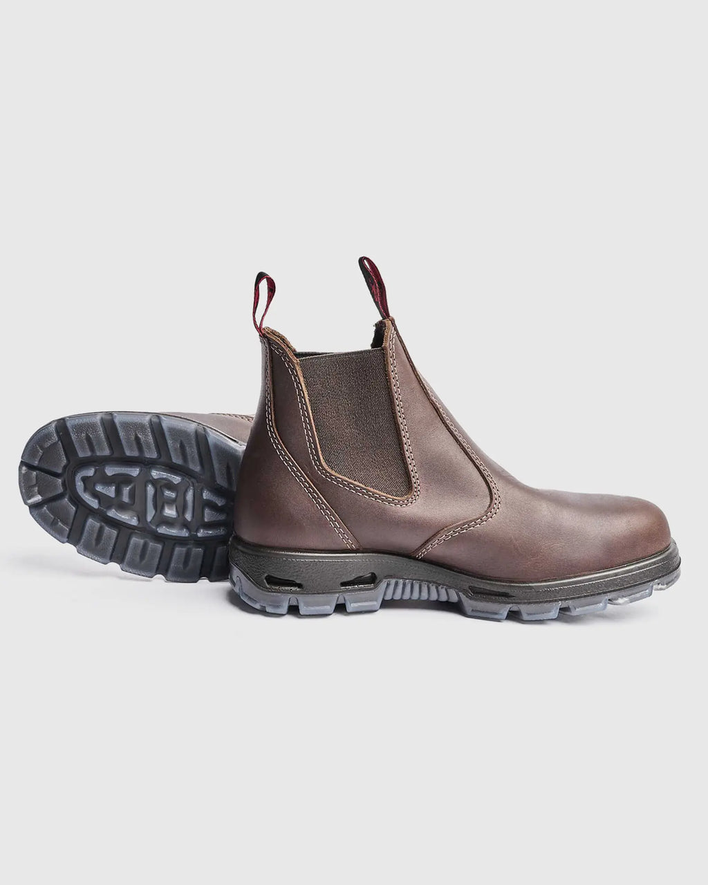 Brown leather chelsea work boot with black sole on a light gray background