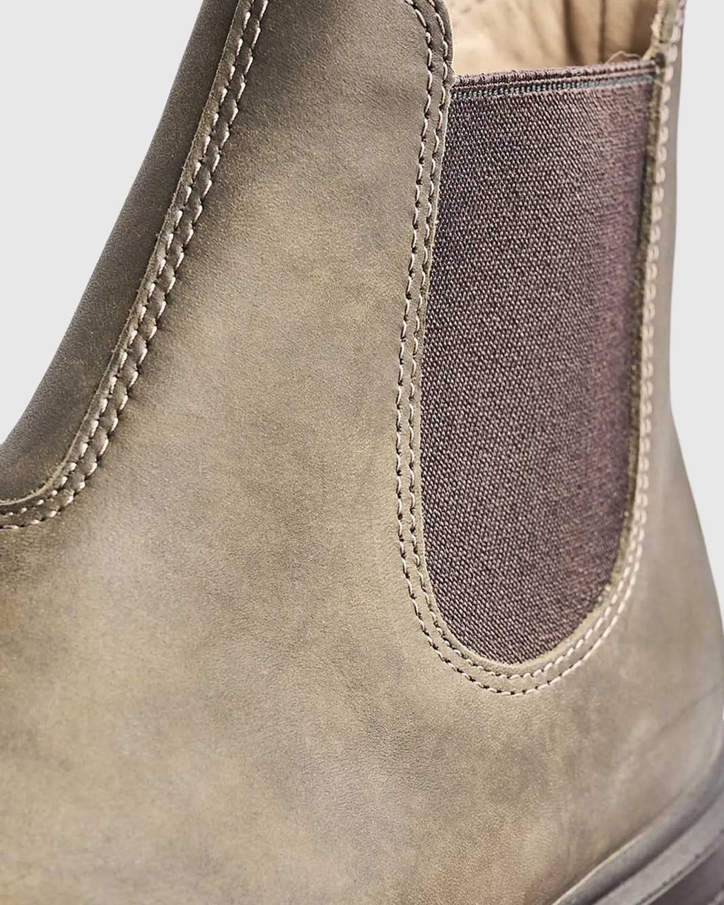 Close-up of a iron bark leather shoe with fabric patch on a light gray background