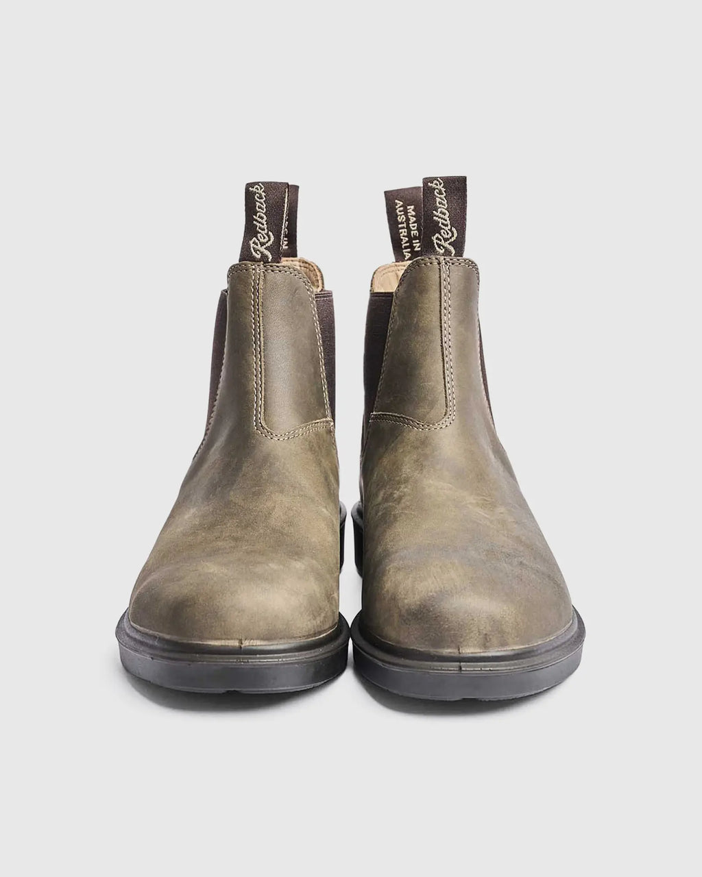 Pair of iron bark leather chelsea lifestyle boots on a light gray background
