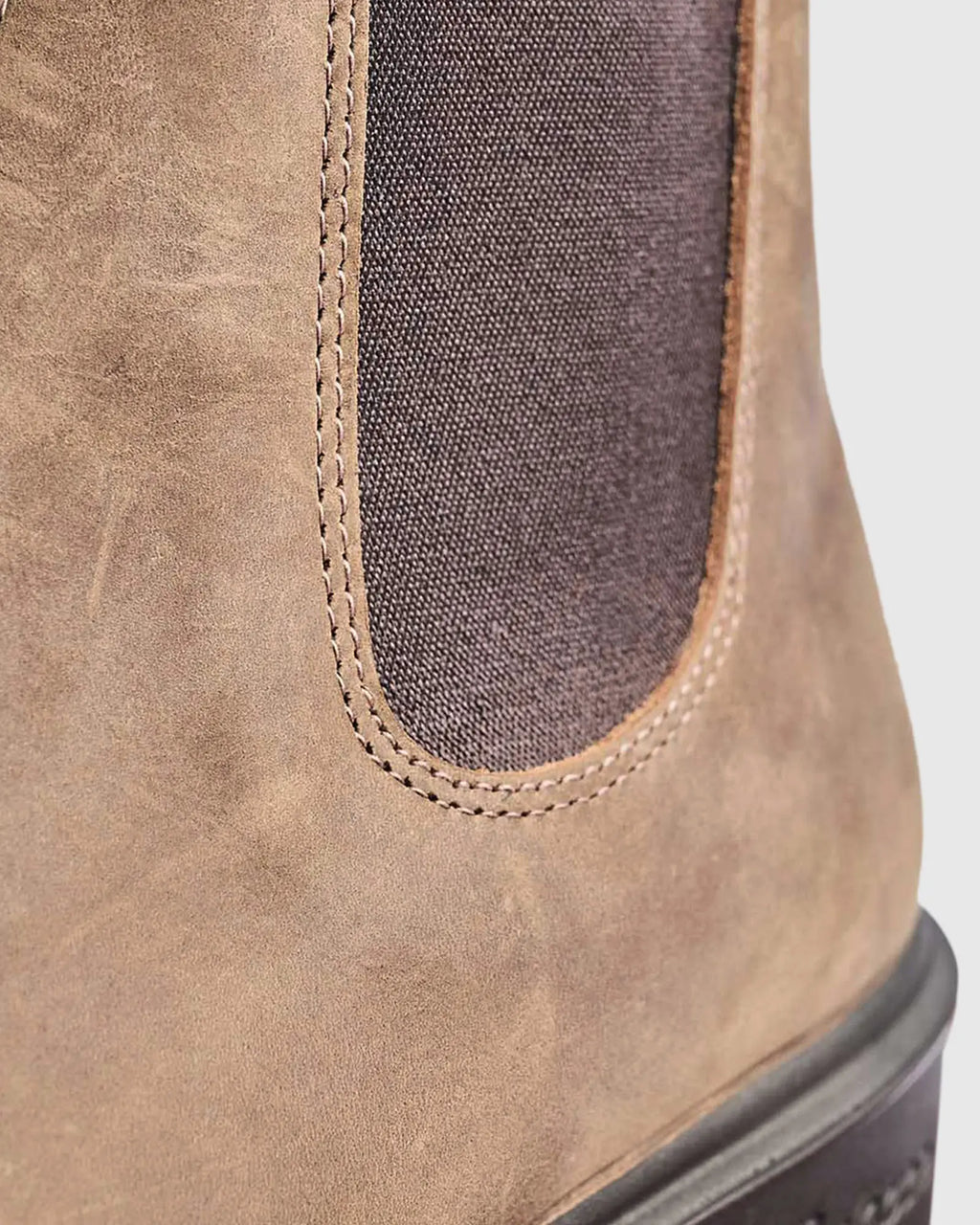 Close-up of a brown leather boot with a gray lining on a white background